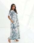 Side profile of the Blue Tropique Linen Blend Jumpsuit highlighting the flowing silhouette, wide sleeves and tropical botanical design.