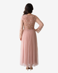 Back view of the Celestial Bloom blush pink tulle evening dress featuring a full-length flowing silhouette and sheer long sleeves.