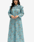 A woman modeling a long-sleeved light blue maxi dress with a detailed floral print and a patterned yoke, set against a plain light gray background.