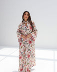 Full-length styled view of ivory linen blend jalabiya with coral-toned sleeve and hem borders