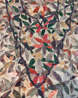 Close-up of Emerald Botanica silk fabric with green coral gold and silver hand beaded neckline