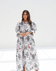 Woman wearing a long, patterned dress on a white background