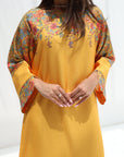 Yellow traditional outfit with floral patterns on a white background