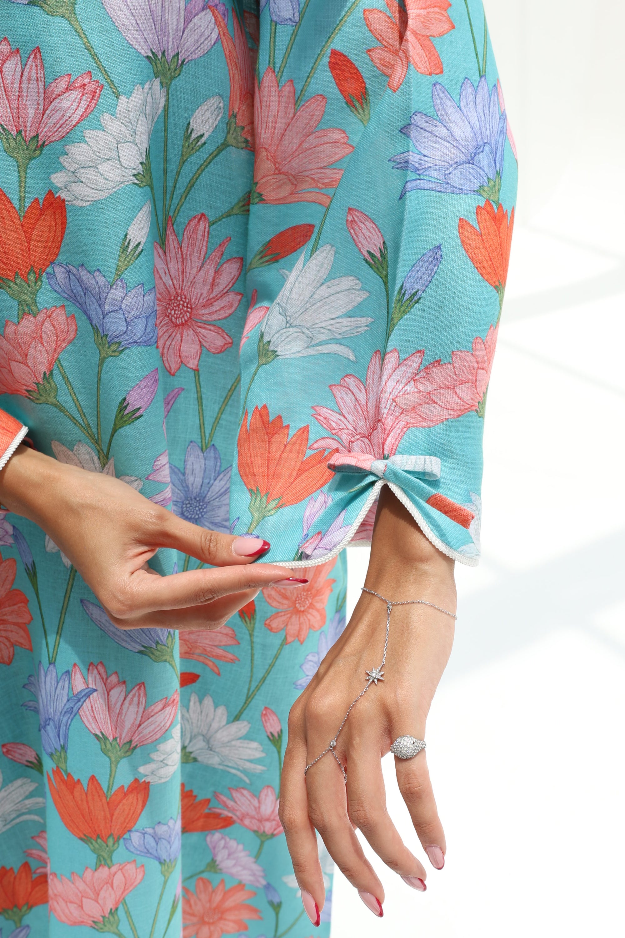 Close-up view of the decorative tie sleeve cuff on the embellished floral jalabiya