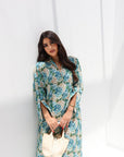 Woman wearing a floral dress against a white background