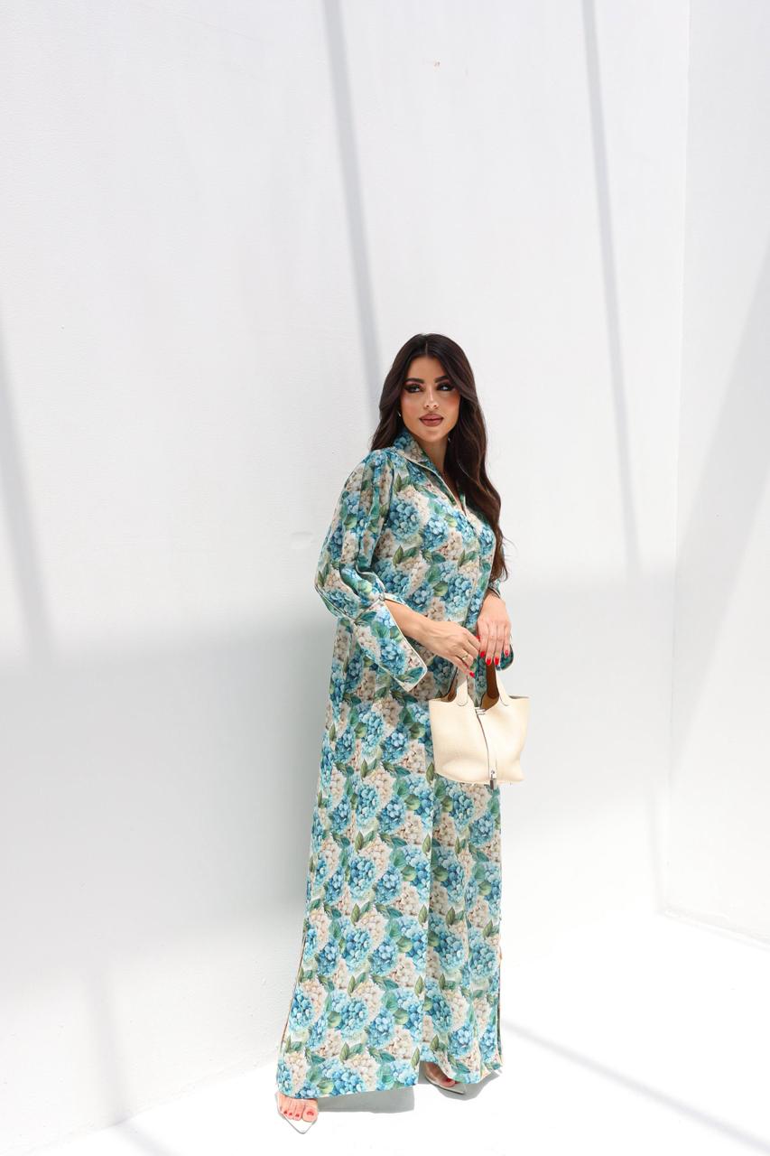 Woman wearing a floral dress holding a white bag against a white background