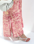 Person wearing pink floral jalabiya with a white background
