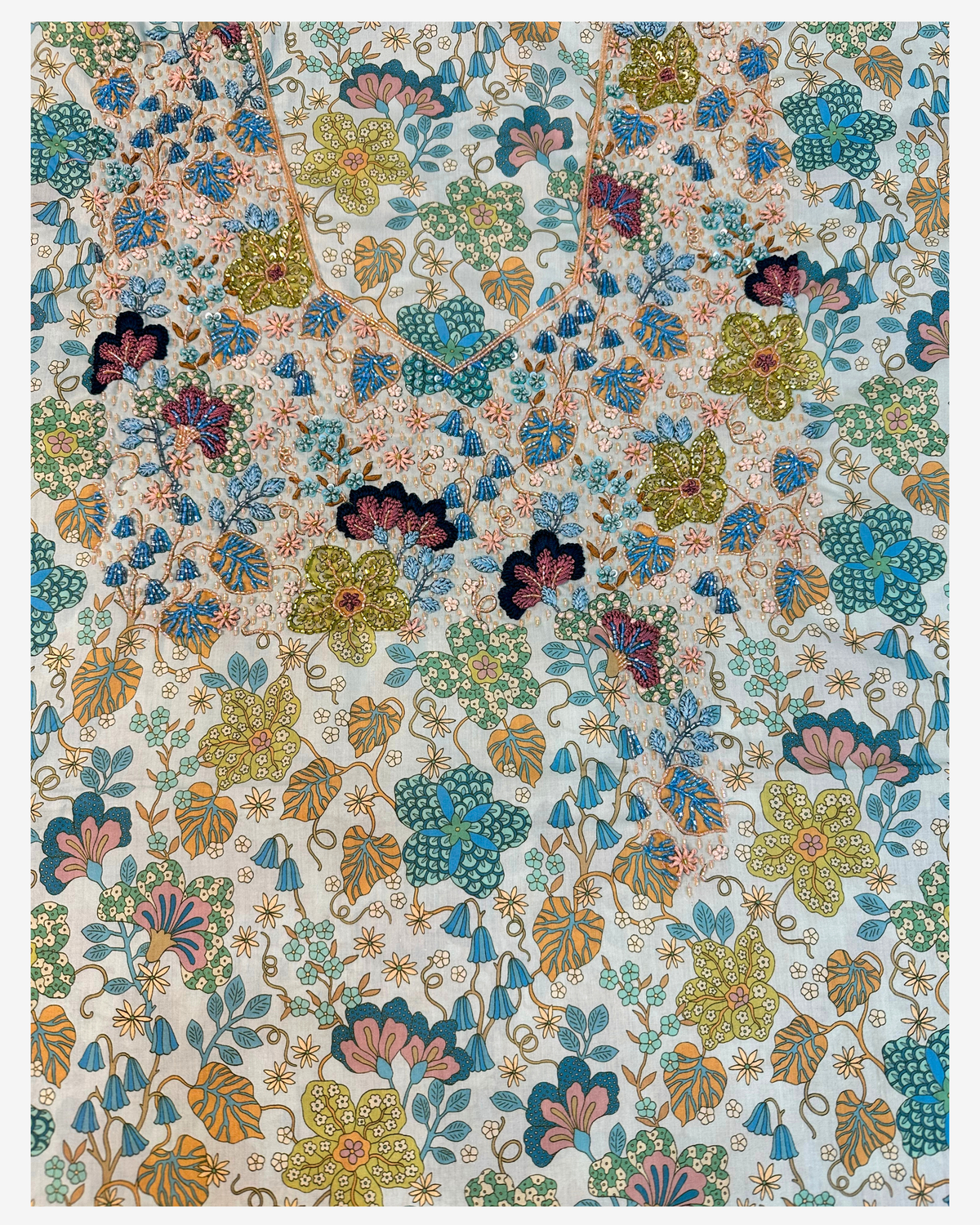 Front view of the hand-beaded open neckline on Italian Liberty mukhawar fabric with a colorful floral print.