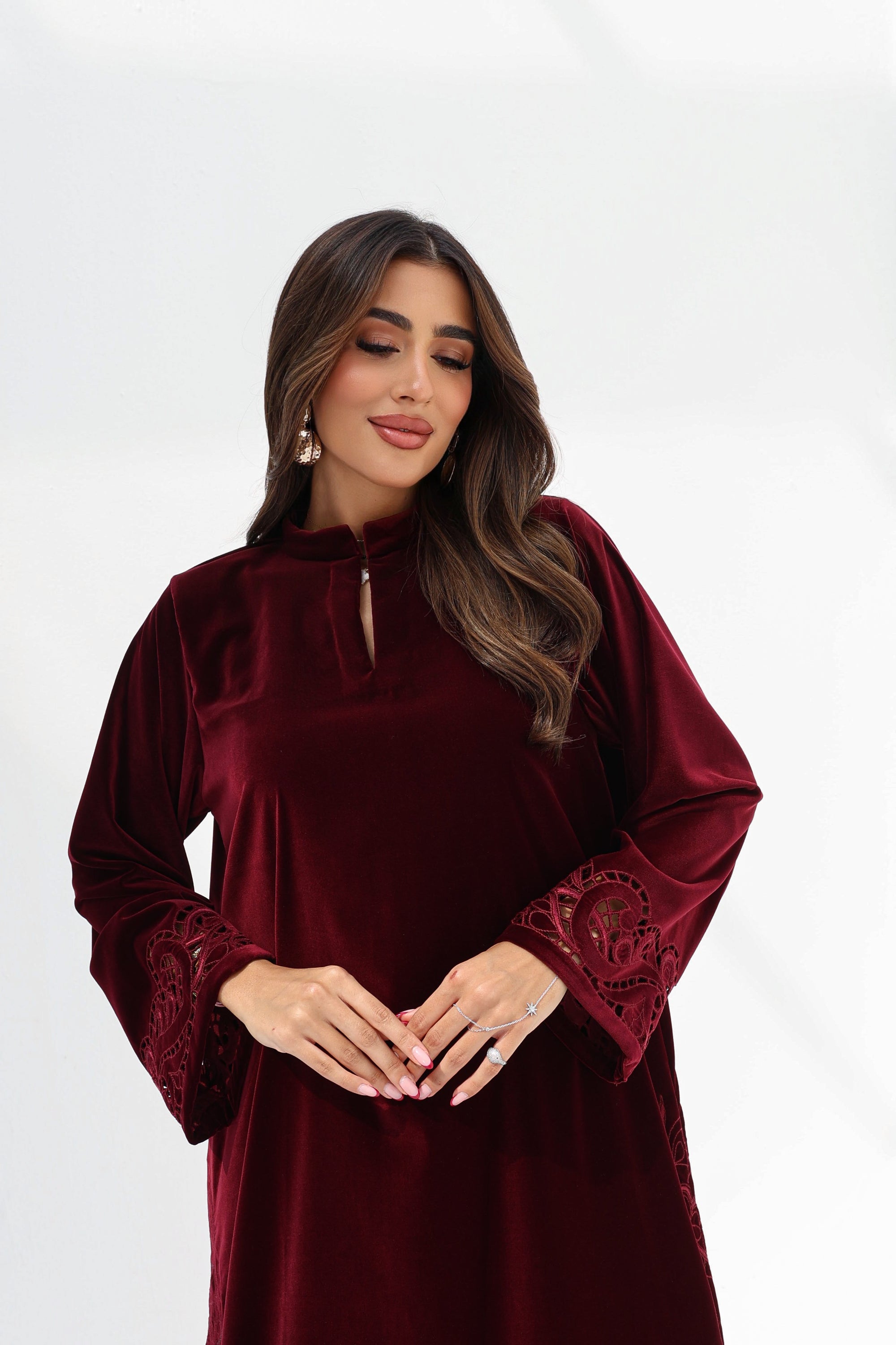  Three-quarter portrait of burgundy velvet jalabiya showing the embroidered sleeve cuffs