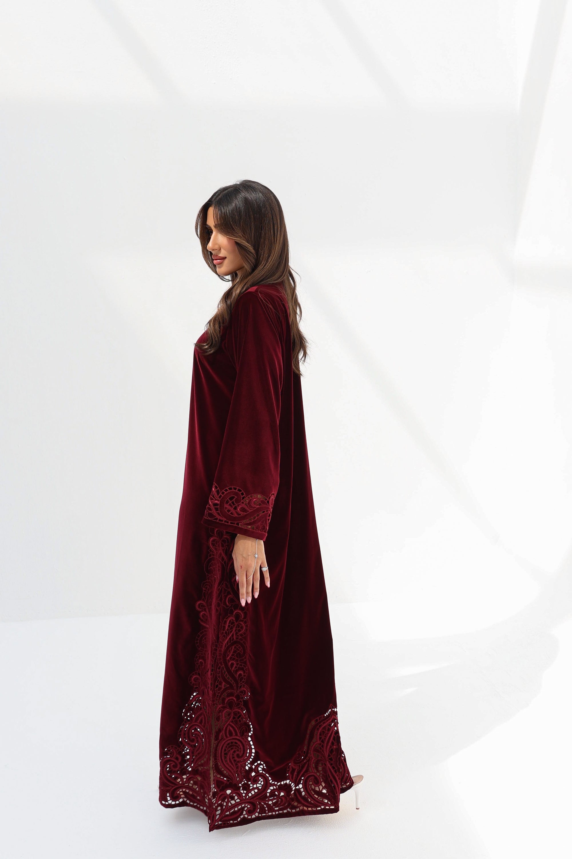 Full-length side view of burgundy velvet jalabiya with embroidered border
