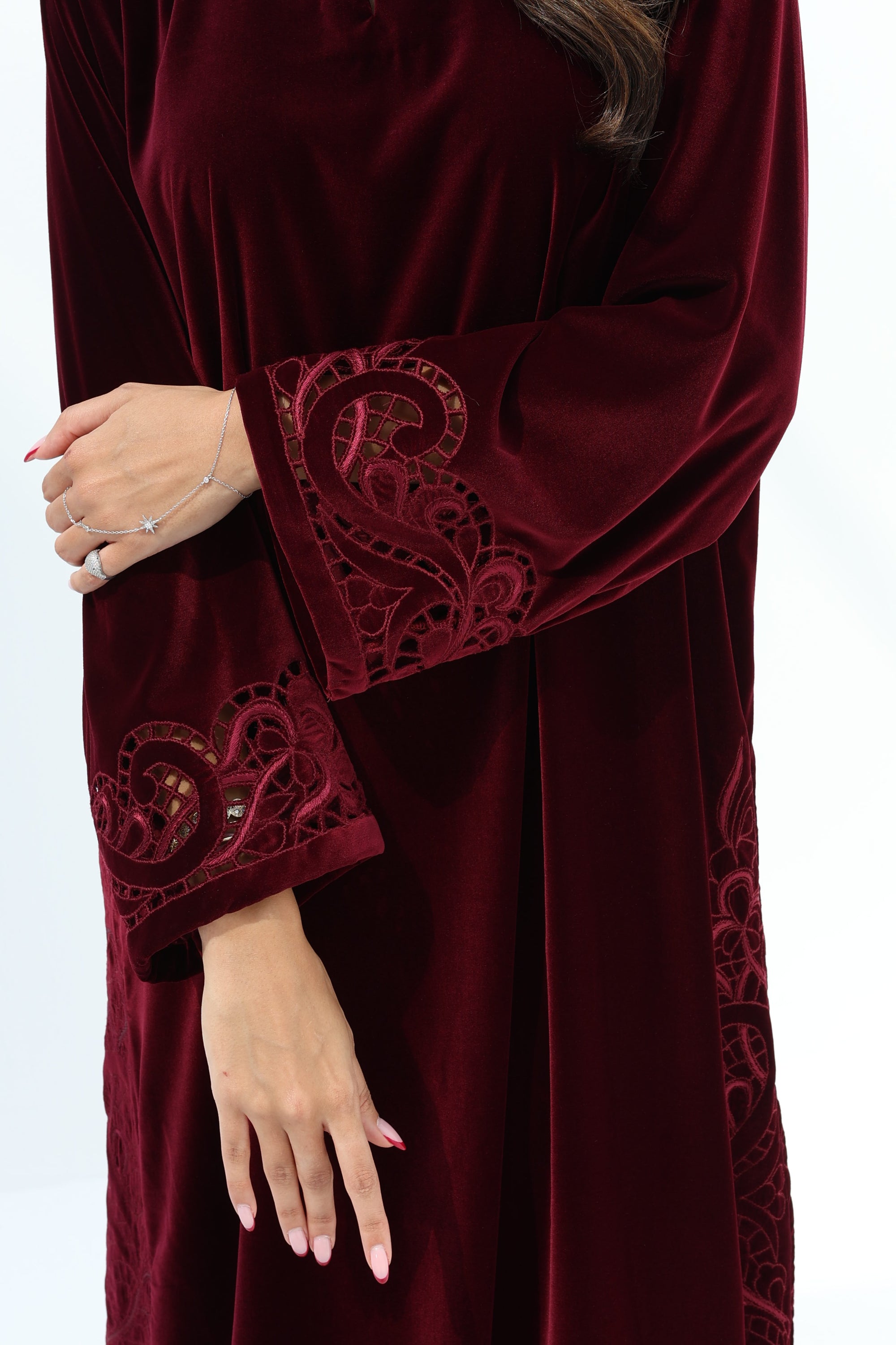Close-up of tonal embroidered detailing on the burgundy velvet sleeve cuff