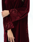 Close-up of tonal embroidered detailing on the burgundy velvet sleeve cuff