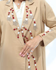 Close-up of colourful hand embellishments on the neckline, front and sleeve cuffs