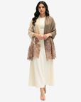A woman modeling a cream-colored dress with a taupe open-front cardigan featuring dusty rose floral lace panels, set against a plain light gray background.