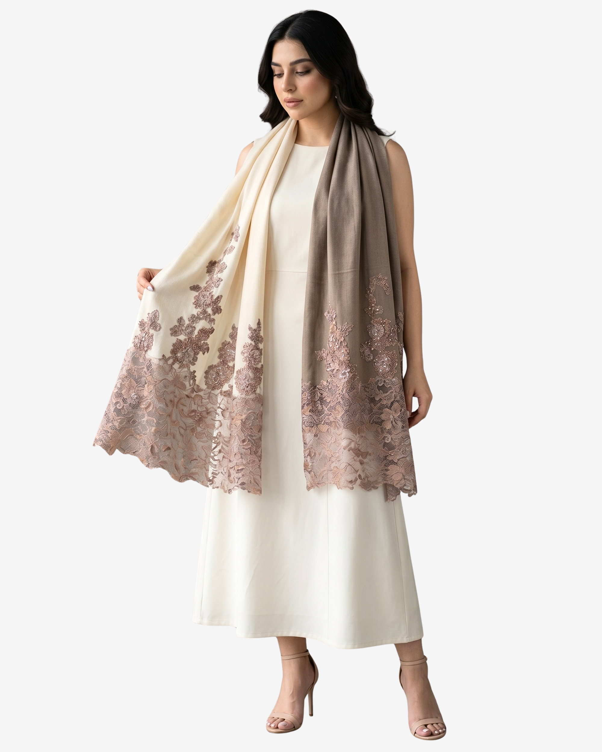 A woman models a long, lightweight shawl draped over a cream-colored dress. The shawl features a gradient transition from cream at the top to a dusty rose-beige at the bottom, with detailed floral embroidery concentrated along the lower edge.