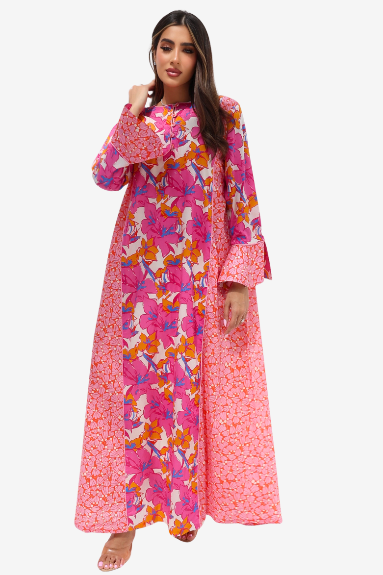 A woman modeling a long cream-colored kurta with a coral-orange leaf print and solid coral-orange striped side panels and cuffs, paired with clear high-heeled sandals against a light gray background.
