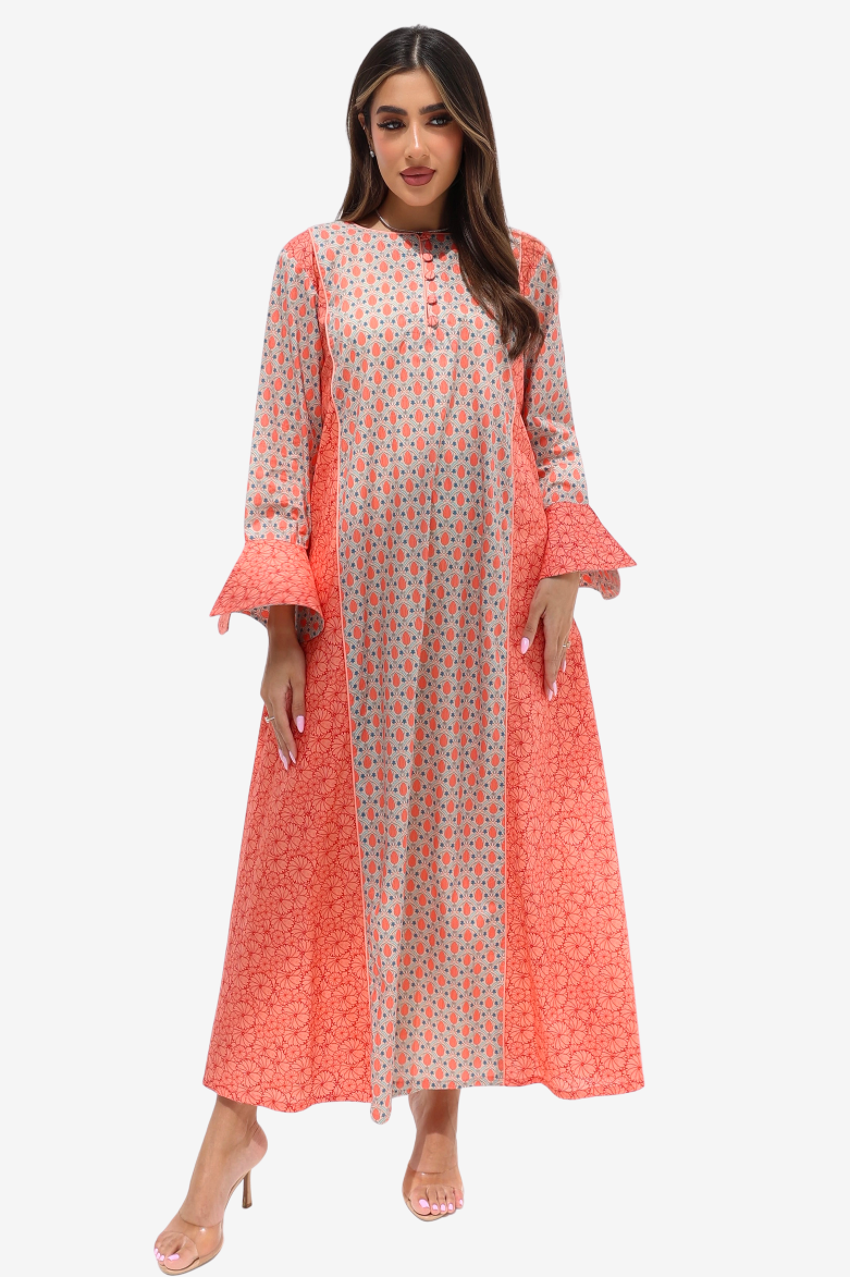 A woman modeling a long-sleeved maxi dress with a split design: one side is coral pink with a small floral print, and the other side is light pink with a dense multicolor floral print. The dress features ruffled bell sleeves and a button-up front.