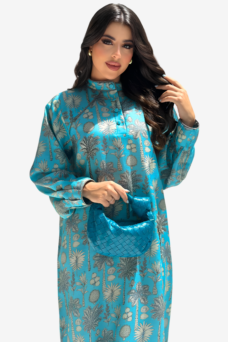 A woman modeling a turquoise blue long-sleeve kurta with a metallic silver floral pattern, holding a matching turquoise clutch bag against a light gray background.