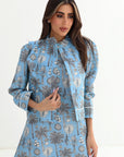 Woman wearing a blue floral dress with a white background
