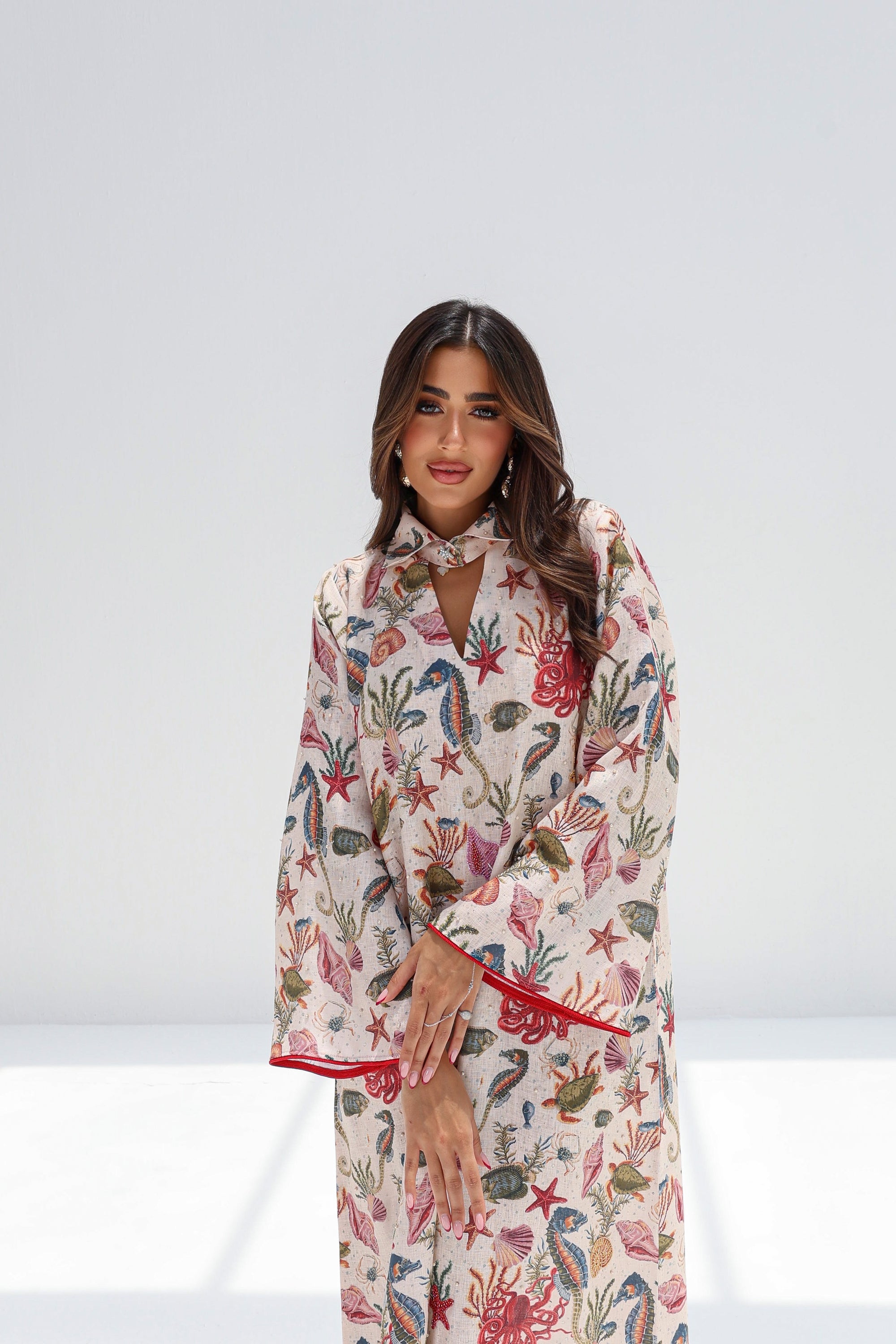 Three-quarter portrait of Coral Reef Embellished Jalabiya showing the flowing sleeves and printed design