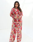 Walking view of the Crimson Bloom Linen Blend Co-Ord Set with wide-leg trousers and elegant floral print by Gharza Couture.