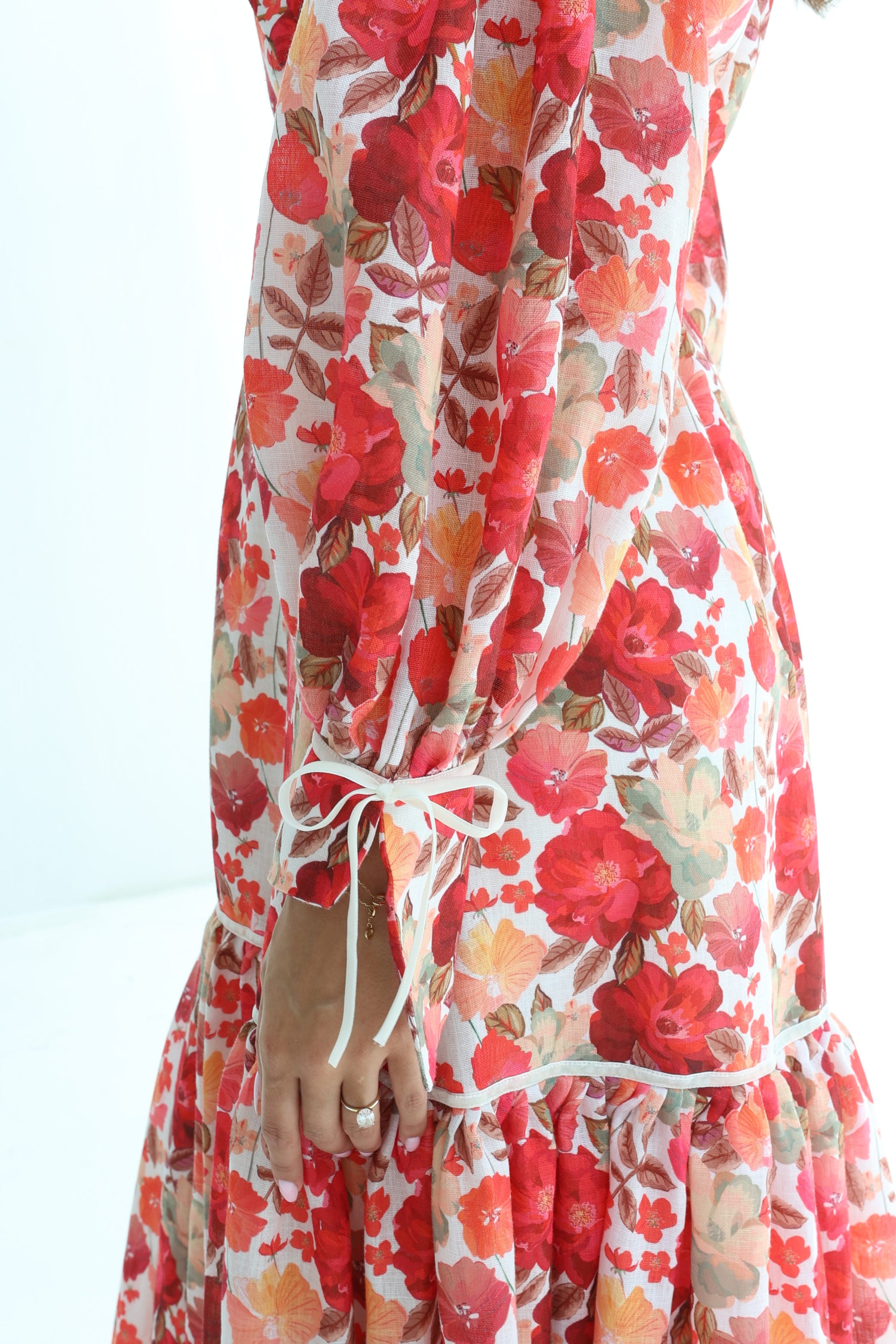 Close-up of Crimson Bloom Linen Blend Dress showing floral print and tiered hem
