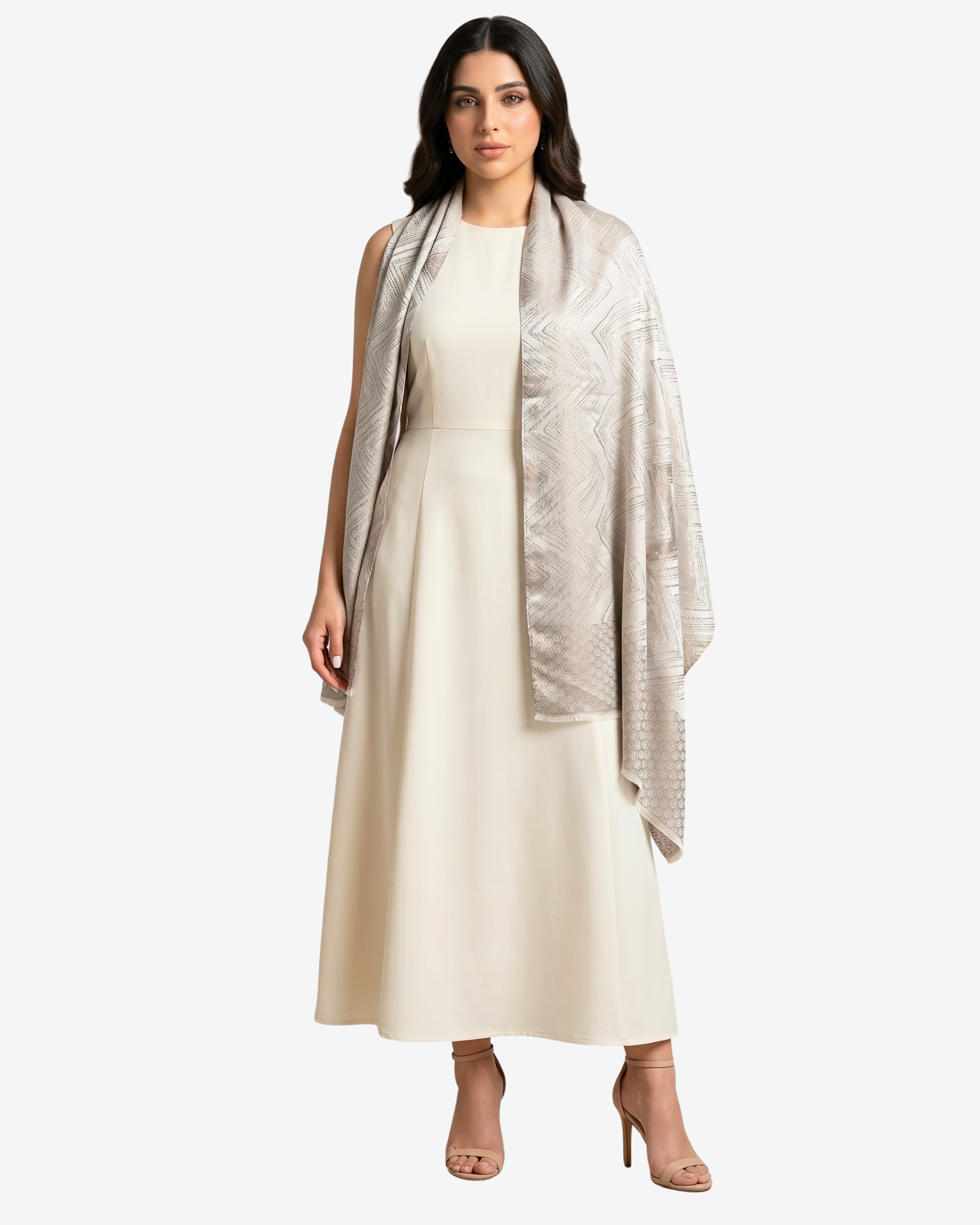 A woman modeling a cream midi dress with a light beige patterned shawl draped over her shoulders, set against a plain light gray studio background.