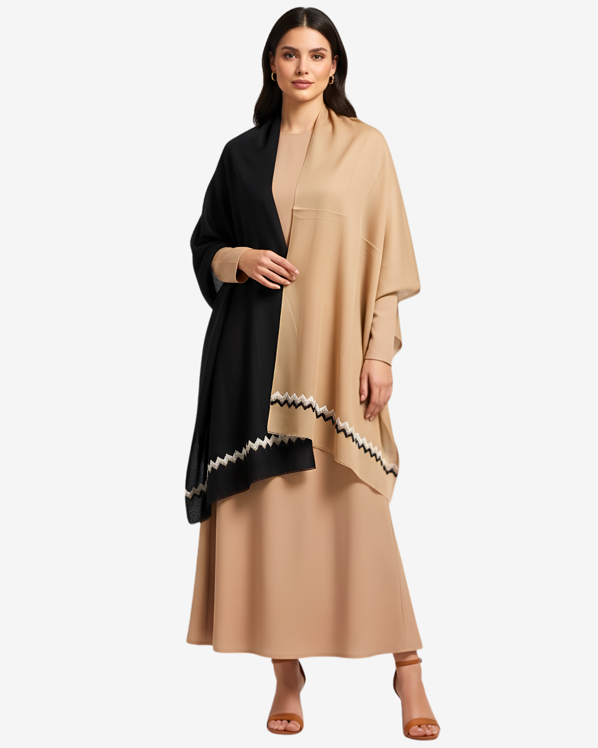 A woman modeling a draped beige and black shawl with a geometric patterned border over a beige maxi dress, set against a plain light gray background.