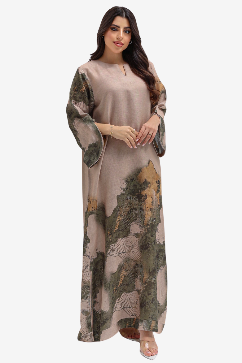 A woman modeling a long, loose-fitting maxi dress with a muted taupe base and an abstract landscape-style print in olive green, brown, and tan, shown against a plain light gray studio background.