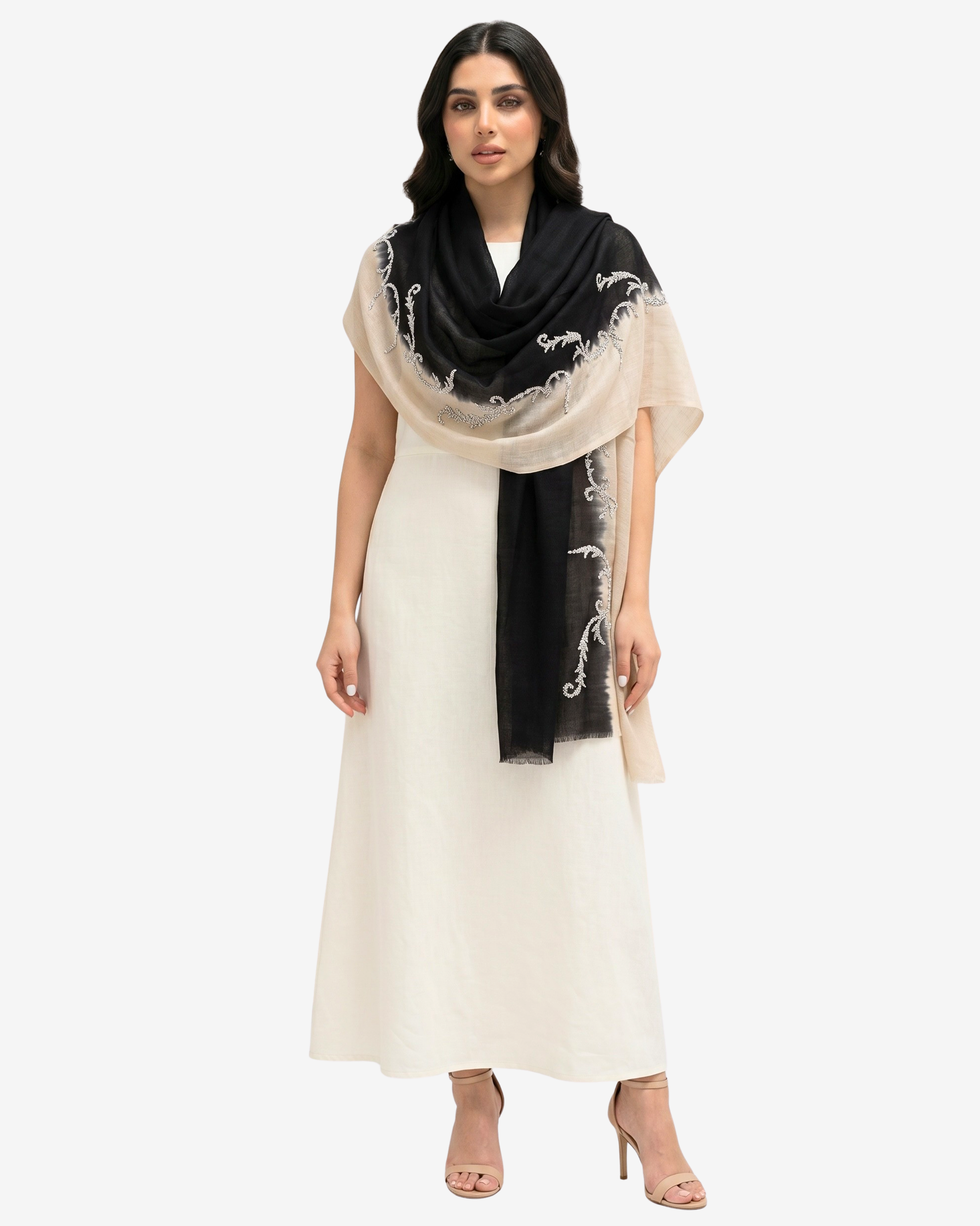 A woman modeling a cream-colored maxi dress with a black and cream dupatta featuring white floral embroidery, set against a plain light gray background.