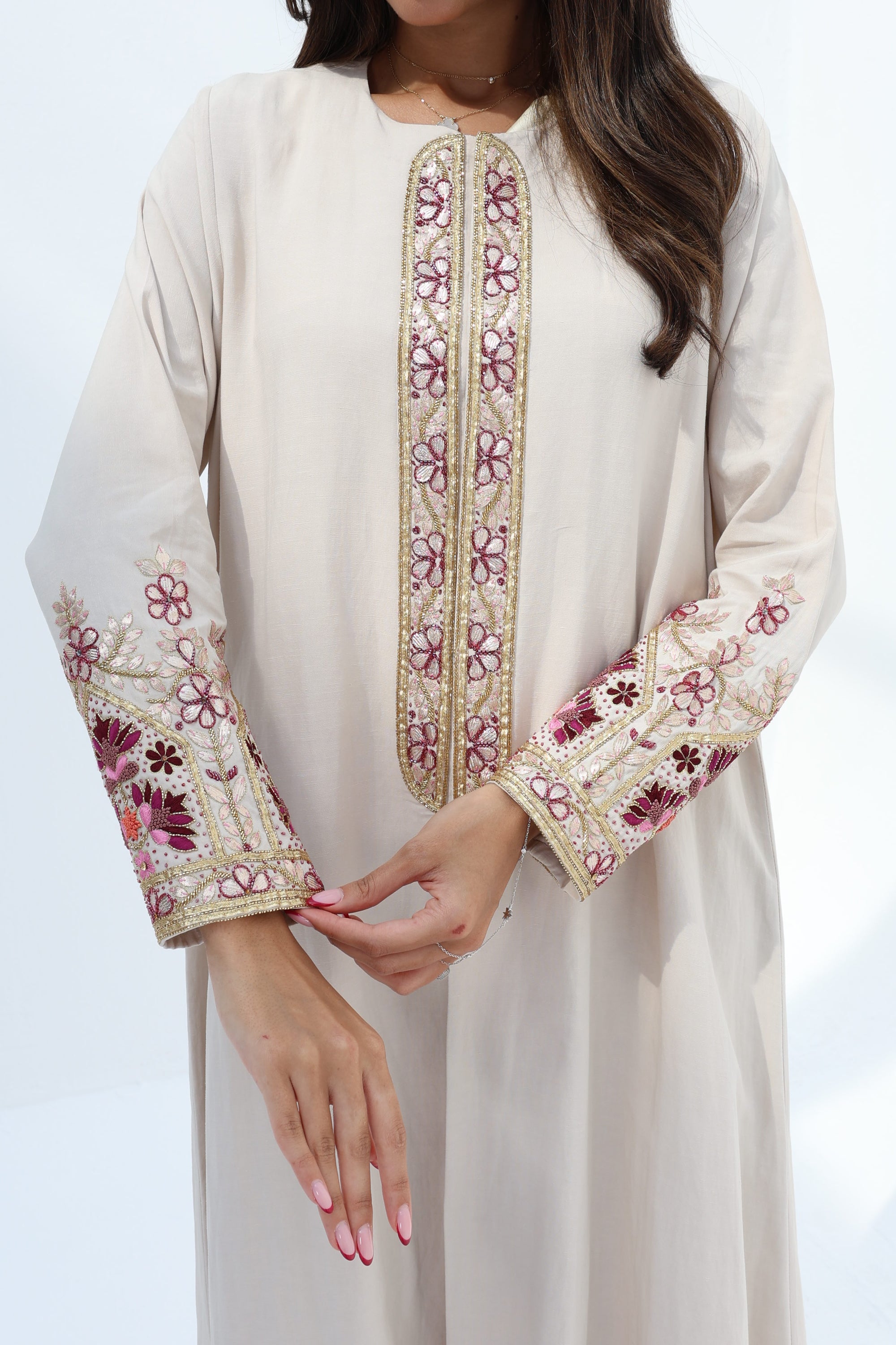 Ivory embroidered abaya showing floral trim along the front and sleeve cuffs