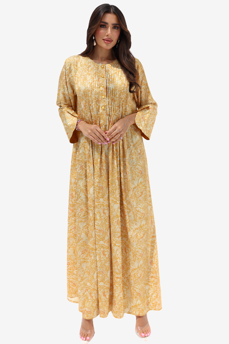A woman modeling a long, loose-fitting golden-yellow dress with a subtle tonal floral pattern, three-quarter bell sleeves, and a round neckline, set against a plain light gray background.