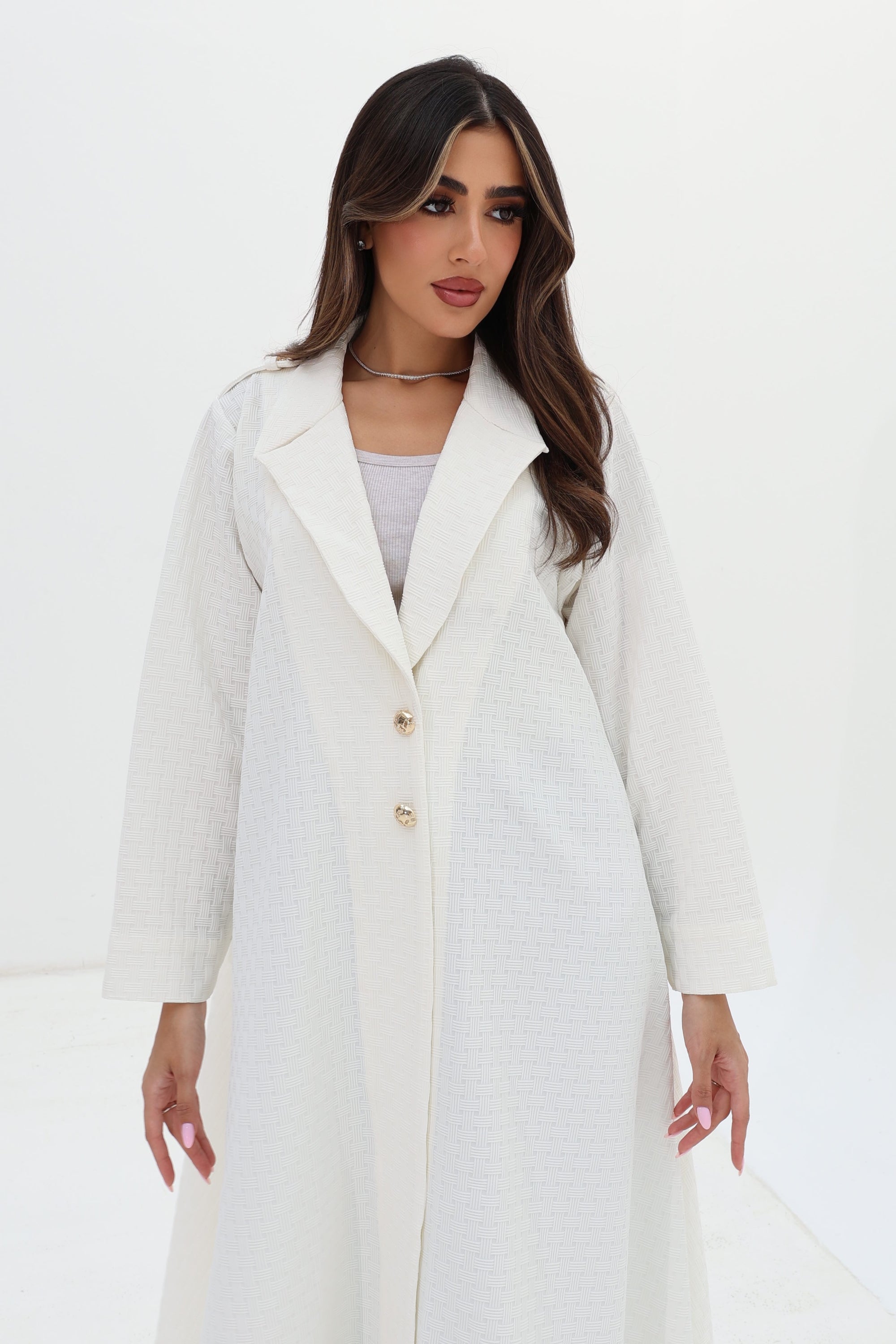 Close-up of the Ivory White Blazer Textured Stretch Abaya by Gharza Couture featuring textured fabric and tailored design.
