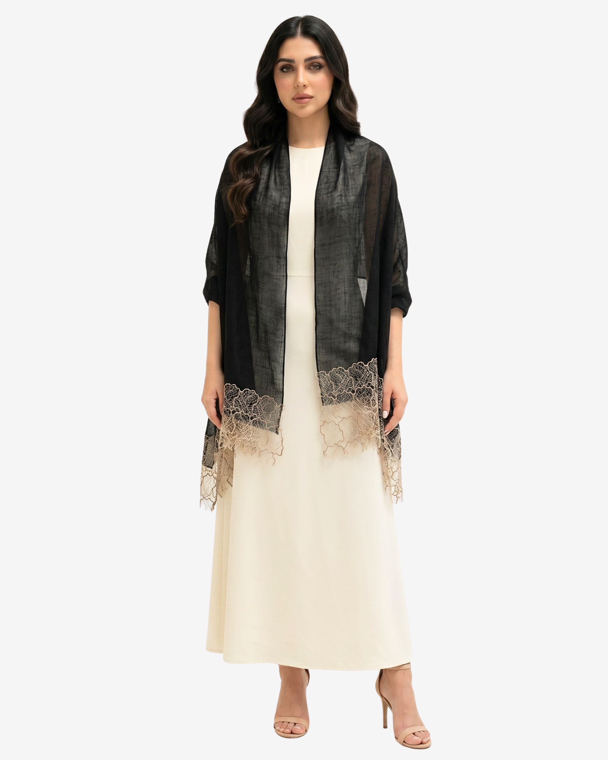 A woman modeling a black sheer open-front cardigan with beige lace trim over a cream maxi dress, standing against a light gray studio background.