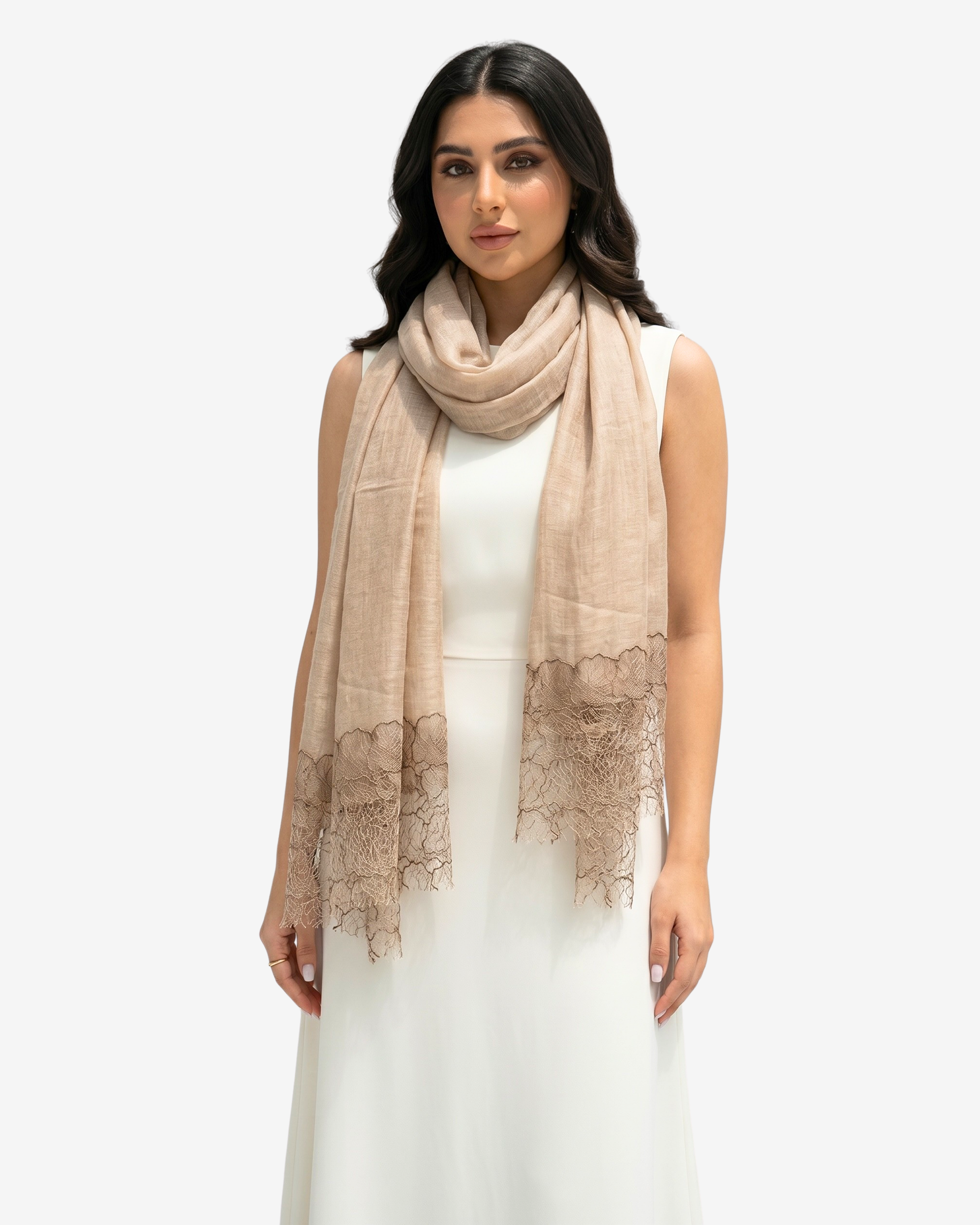 A woman modeling a light beige scarf with delicate lace trim at the ends, worn over a white sleeveless dress against a plain light gray background.