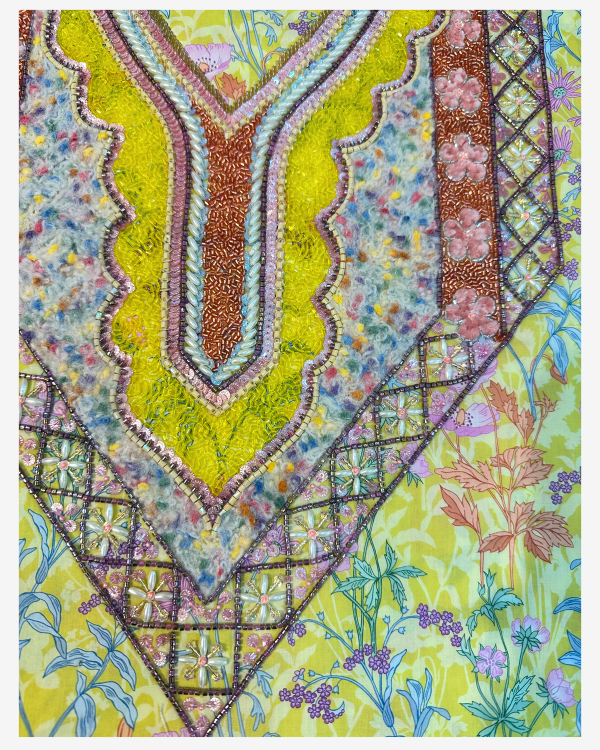 Close-up of a layered hand-beaded neckline with lime, copper, pale blue and multicoloured textured details on Liberty fabric.