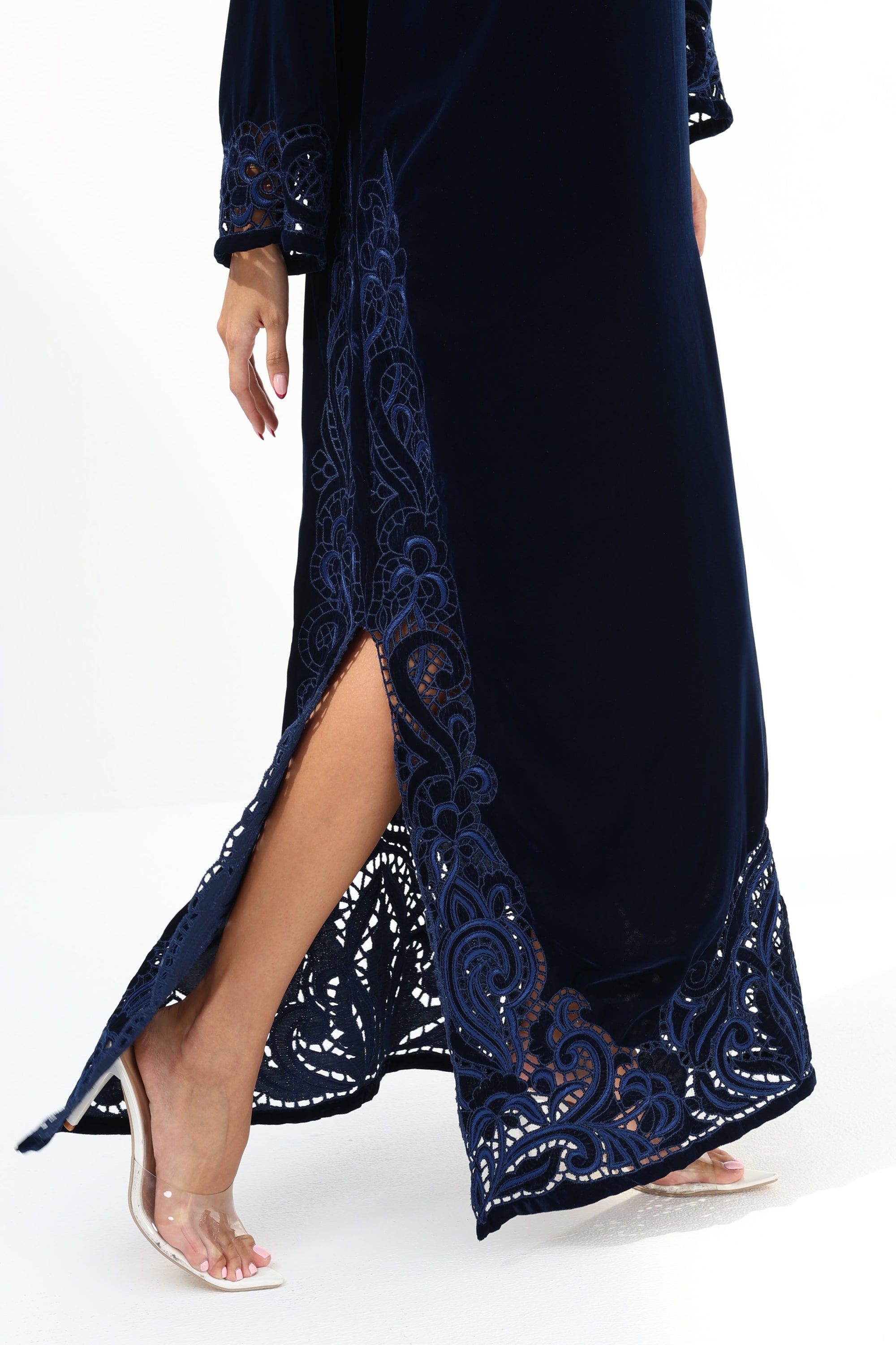 Lower hem detail of navy velvet jalabiya with hand embroidery and high side slit

