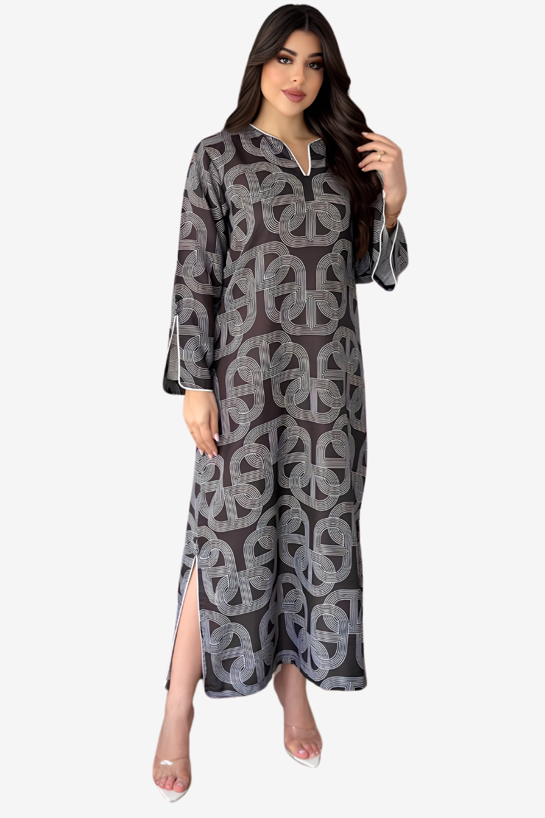 A woman modeling a long-sleeved, floor-length kaftan dress with a gray and black geometric peace-sign pattern, shown against a plain light gray background.