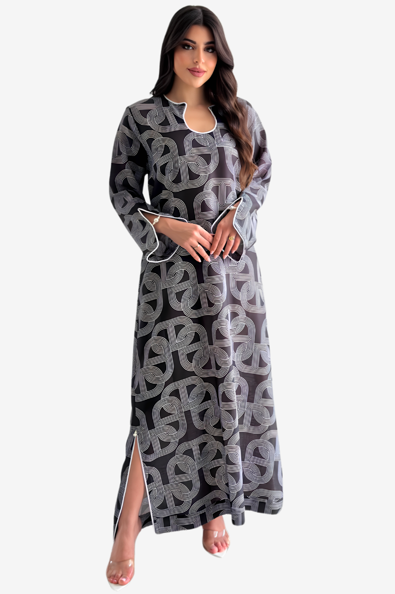 A woman modeling a long-sleeved black maxi dress with a gray geometric pattern, shown against a plain light gray background.