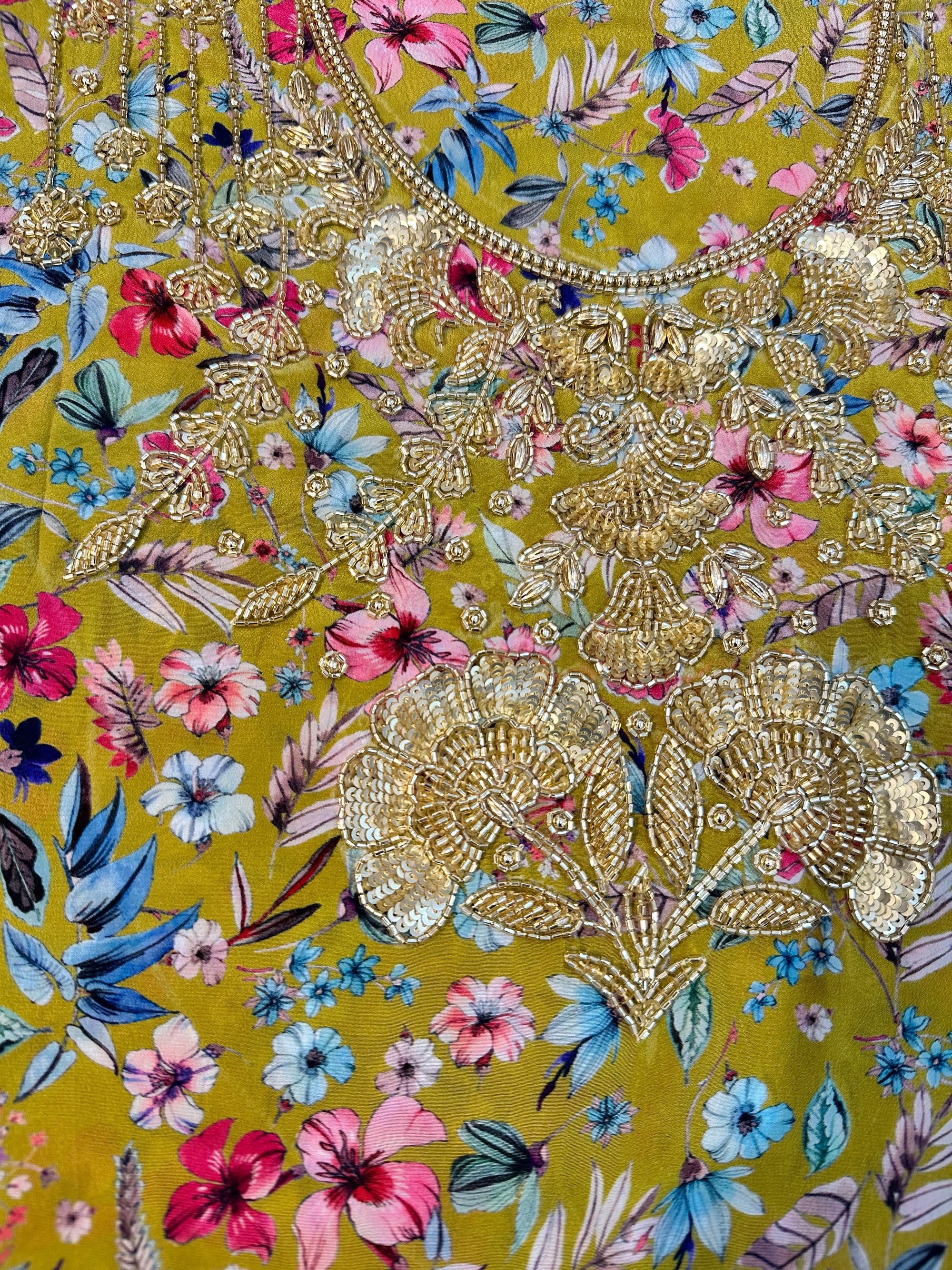 Premium crepe fabric displaying the mustard wildflower print of the Mustard Wildflower Crepe Mukhawar for custom tailoring by Gharza Couture.