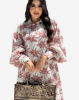 A woman wearing a white long-sleeve shirt with a pink palm tree pattern, holding a Christian Dior tote bag against a light gray background.