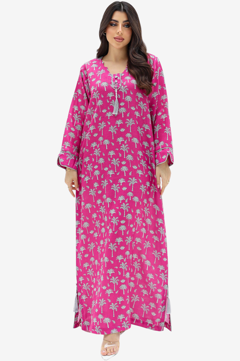 A woman modeling a long magenta pink maxi dress with a light gray palm tree pattern, set against a plain light gray background.