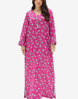 A woman modeling a long magenta pink maxi dress with a light gray palm tree pattern, set against a plain light gray background.