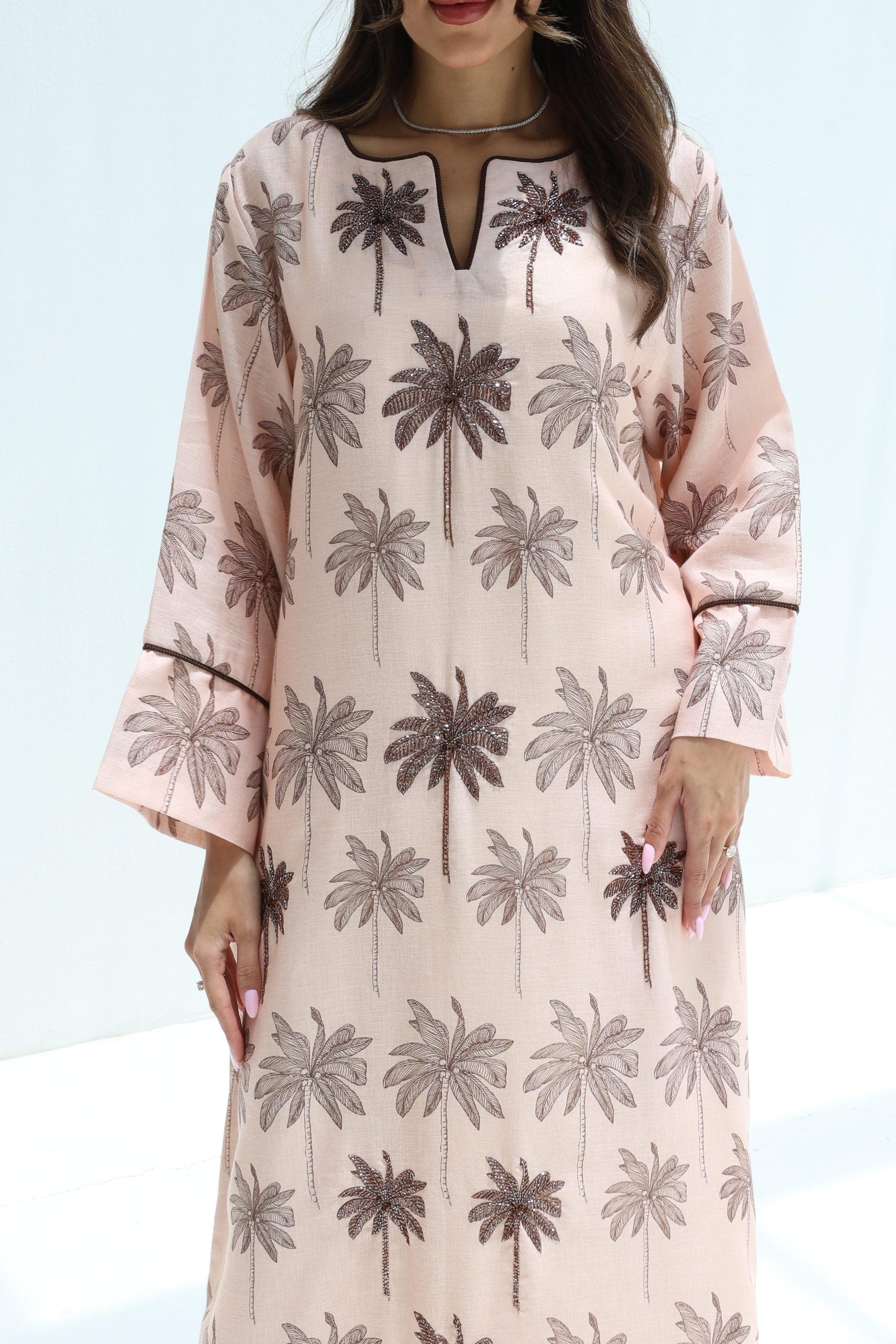 Front detail of Palm Sketch Jalabiya featuring a round embellished neckline and flared cuffs
