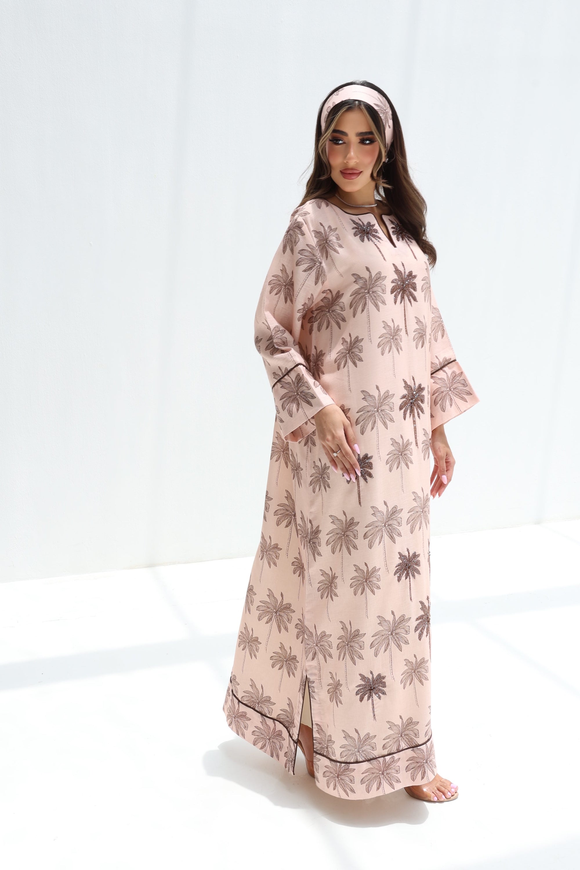 Full-length side view of blush linen blend jalabiya with charcoal palm print and border detailing