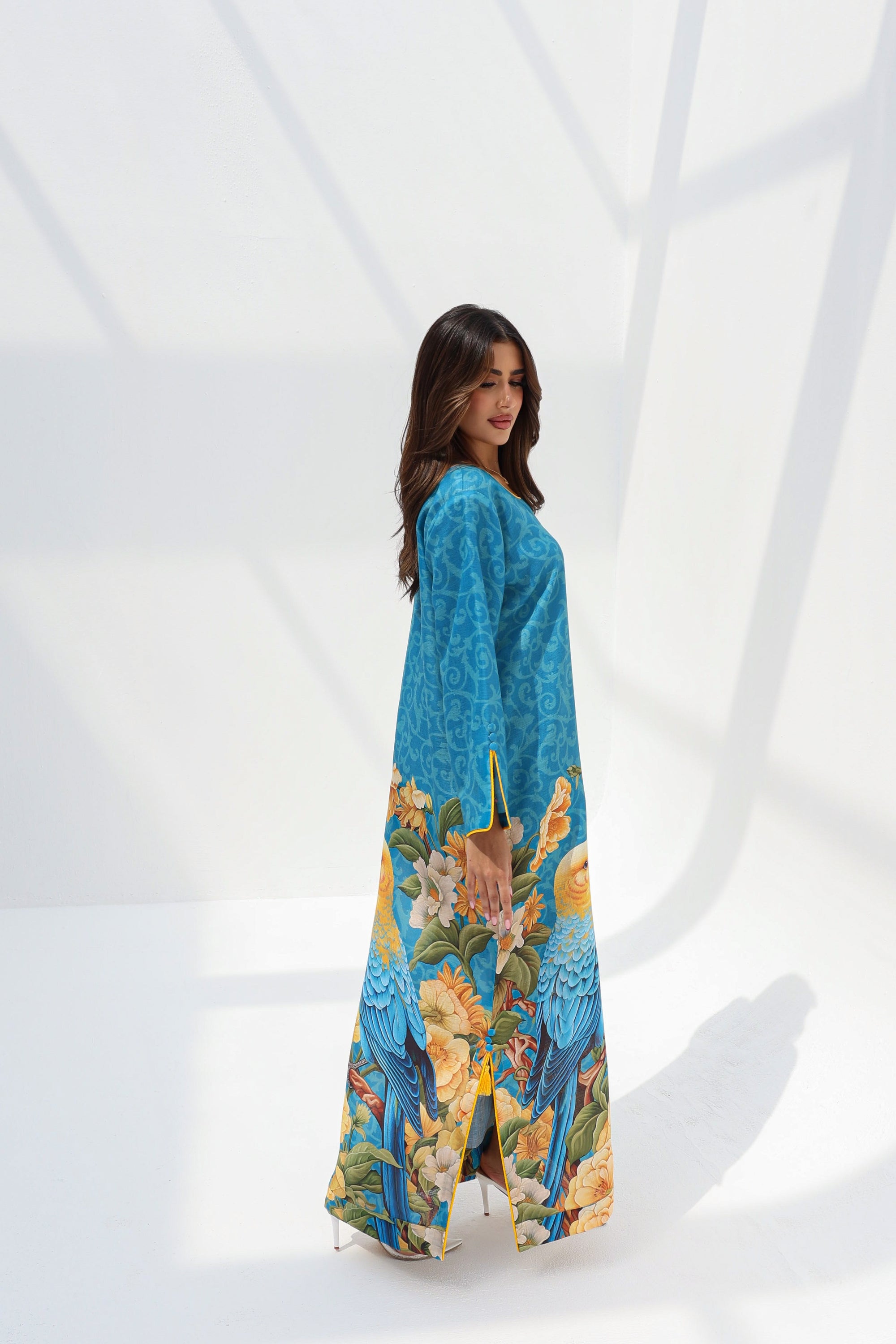 Full-length side view of turquoise jalabiya with tropical bird and botanical placement print
