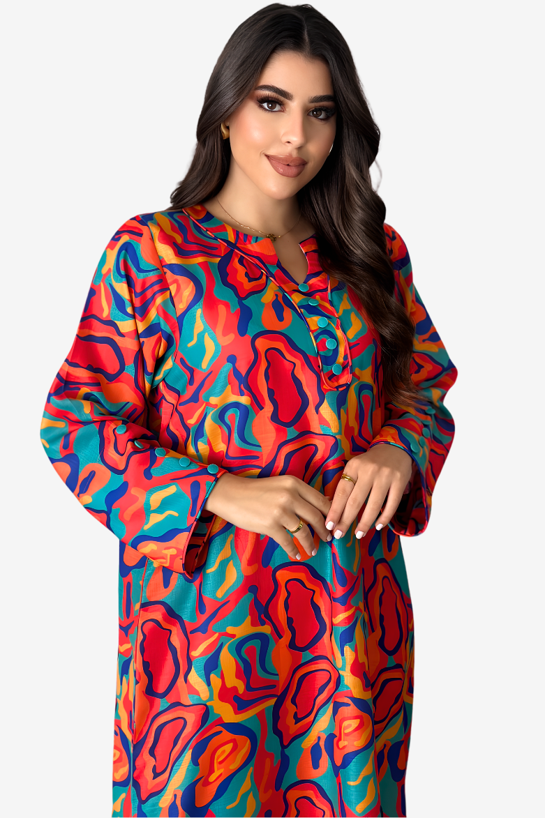A woman wearing a long-sleeve collared button-front dress with a bold abstract wavy pattern in red, orange, blue, and yellow, photographed against a light gray studio background.