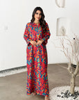 Woman wearing a colorful patterned outfit standing in a modern indoor setting.