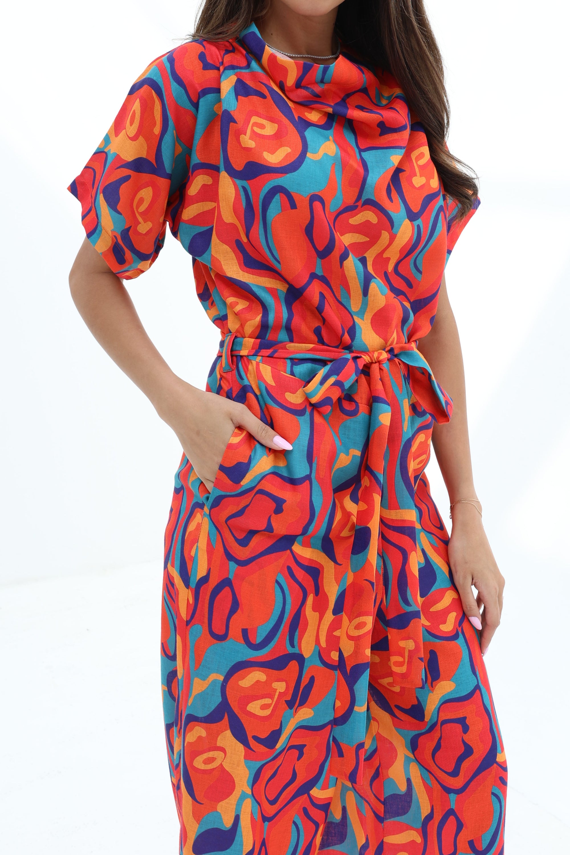 Close-up of the Prism Flow Sunset Abstract Linen Blend Jumpsuit highlighting the abstract print, draped neckline and self-tie waist belt.