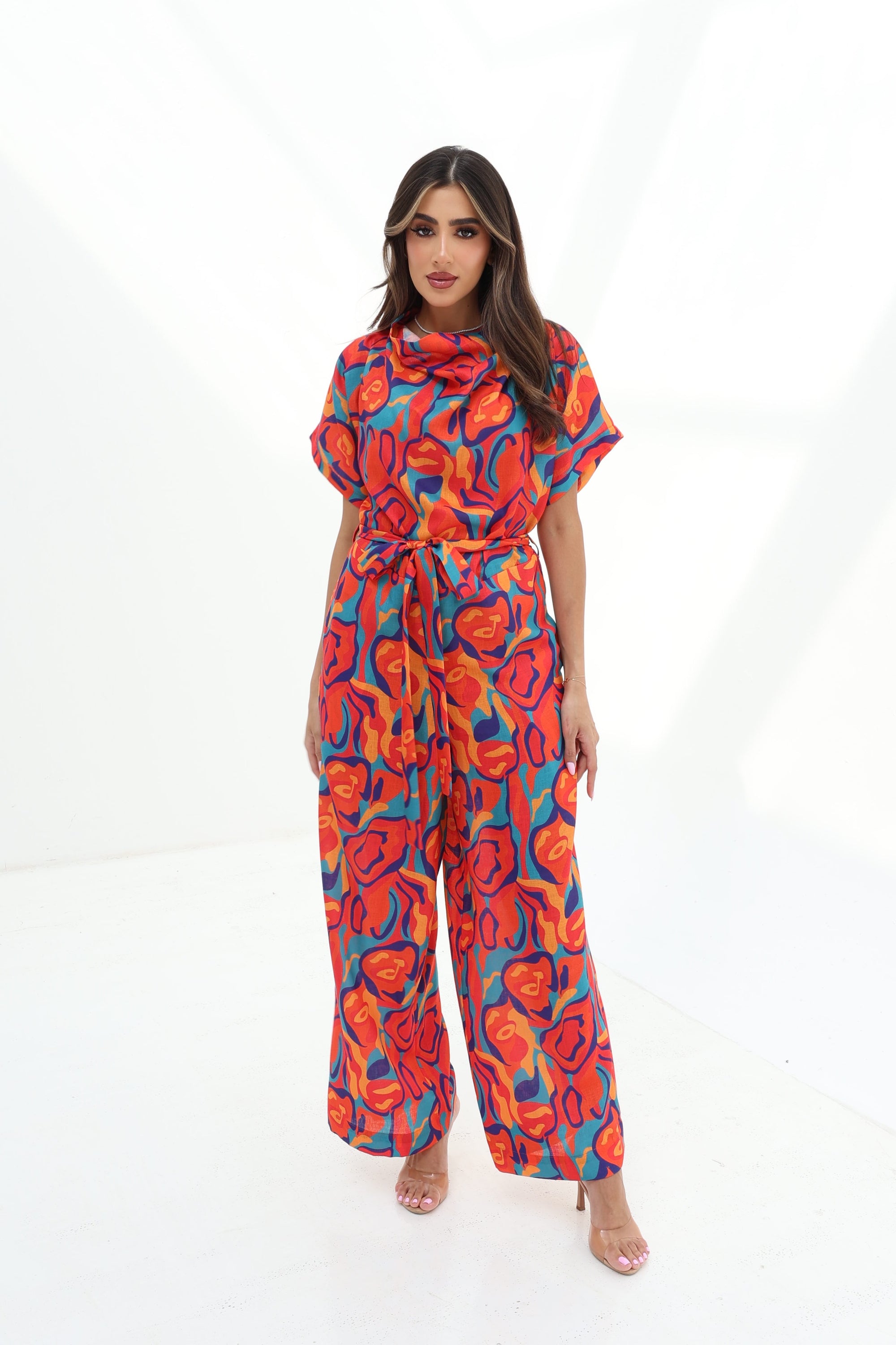 Full-length view of the Prism Flow Sunset Abstract Linen Blend Jumpsuit with relaxed silhouette and vibrant abstract sunset-inspired print.